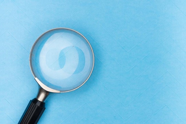 A magnifying glass sits on a blue table